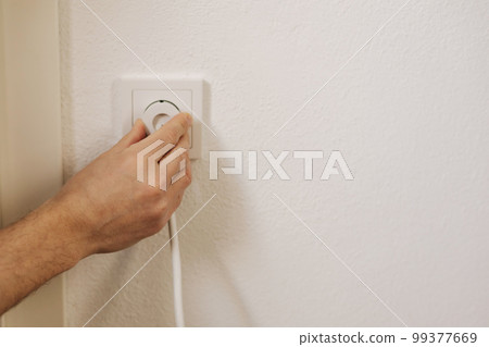 First person view of man's hand puts the charger in the socket 99377669