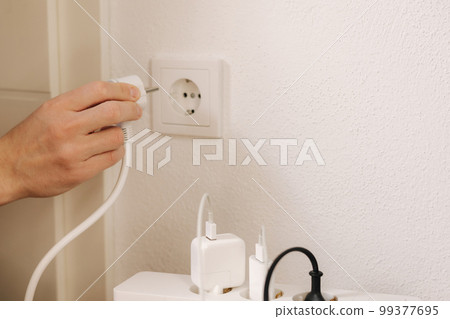 The extension cord filled with chargers is connected to a 220V outlet 99377695