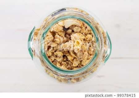 Glass jar of muesli and granola on wooden background. Healthy breakfast. Top view. 99378415