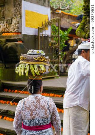 A Balinese woman enters a Hindu temple with offerings on her head (Bali, Indonesia) A Balinese woman enters a Hindu temple with offerings on her head (Bali, Indonesia) 99379651