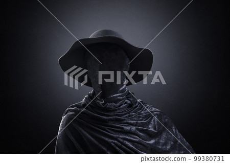 Creepy figure with old hat over dark misty background Creepy figure with old hat over dark misty background 99380731