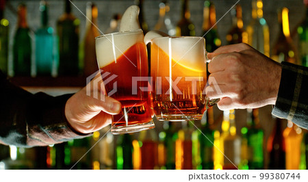 Close-up view of a two glasses of beer in hands. 99380744