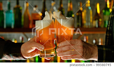 Close-up view of a two glasses of beer in hands. 99380745