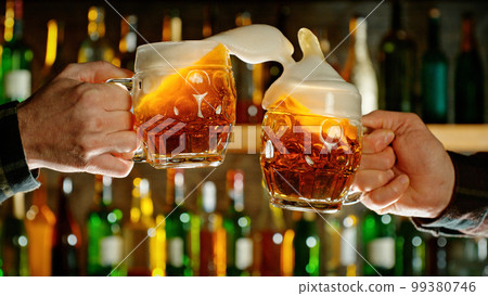 Close-up view of a two glasses of beer in hands. 99380746