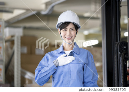 Warehouse management staff image A woman in work clothes smiling looking at the camera Warehouse management staff image A woman in work clothes smiling looking at the camera 99383705