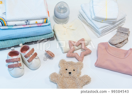 Baby clothes and accessories on white background. Top view of baby girl pink clothes and items 99384543
