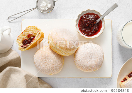 Berliner donut. Traditional german donut with raspberry jam, dusted with icing sugar. Top view Berliner donut. Traditional german donut with raspberry jam, dusted with icing sugar. Top view 99384848