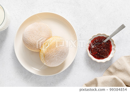 Berliner donut. Traditional german donut with raspberry jam, dusted with icing sugar. Top view Berliner donut. Traditional german donut with raspberry jam, dusted with icing sugar. Top view 99384854