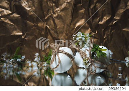White Easter eggs with flowers on golden background, close up White Easter eggs with flowers on golden background, close up 99386304