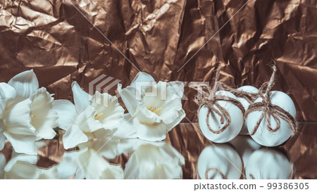 White Easter eggs with flowers on golden background, close up White Easter eggs with flowers on golden background, close up 99386305