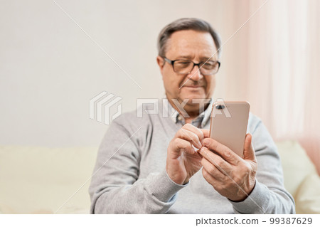 Portrait of smiling mature man using mobile phone 99387629