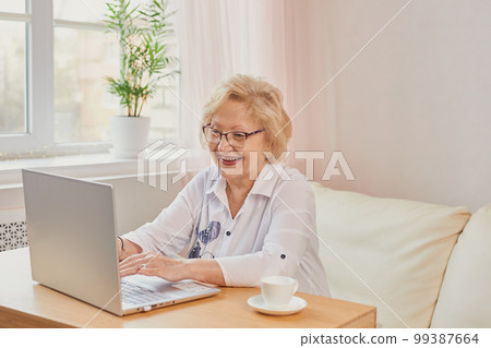 Happy mature middle aged elderly woman reading good news looking at laptop 99387664