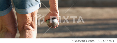 Senior playing petanque un and relaxing game. Senior woman prepared to throw the boules ball in a park in outdoor play Senior playing petanque un and relaxing game. Senior woman prepared to throw the boules ball in a park in outdoor play 99387704