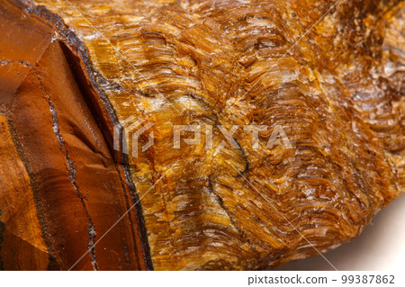 Macro mineral stone Tiger's eye in the breed on a white background 99387862