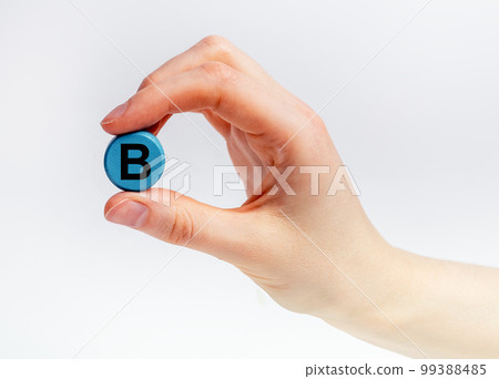 B vitamin tablet, dietary supplement in hand close up 99388485