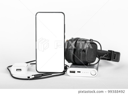 Mobile phone screen mockup, smartphone display mock up with stuff for travel. Headphones, portable charger, cords, wires 99388492