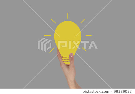 Hand holding glowing light bulb. Idea, inspiration, creativity concept on grey background. 99389052