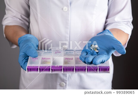 Pharmacy concept. Pill box, plastic case, tablet and medicines organizer, vitamin container in pharmacists hands close up 99389065