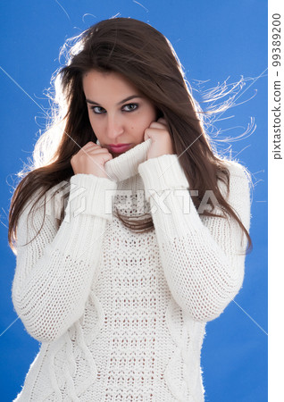 attractive young millennial woman posing on blue background with cold 99389200