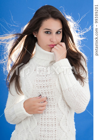 attractive young millennial woman posing on blue background with cold 99389201