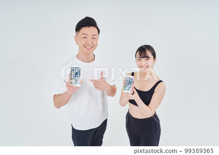 穿著運動服的男人和女人用智能手機 穿著運動服的男人和女人用智能手機 99389365