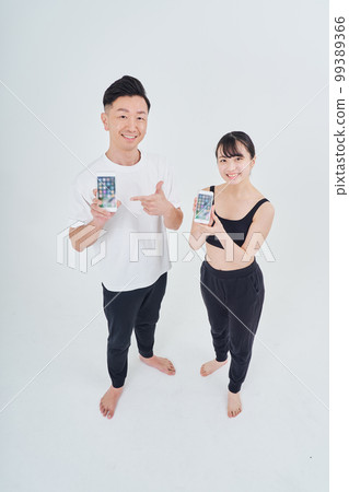 Men and women in sportswear with smartphones Men and women in sportswear with smartphones 99389366