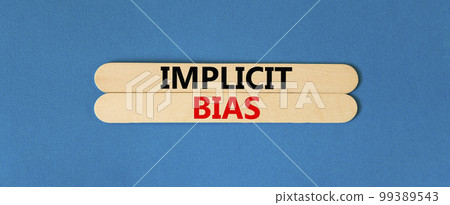 Implicit bias symbol. Concept words Implicit bias on wooden sticks. Beautiful blue table blue background. Business psychology implicit bias concept. Copy space. 99389543
