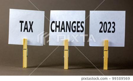 Tax changes 2023 symbol. Concept words Tax changes 2023 on white paper on clothespin on a beautiful grey table grey background. Business Tax changes 2023 concept. Copy space. 99389569