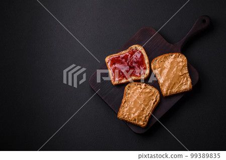 Nutritious sandwiches consisting of bread, raspberry jam and peanut butter 99389835