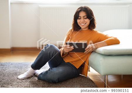 Technologies For Leisure. Beautiful Middle Eastern Female Using Digital Tablet At Home Technologies For Leisure. Beautiful Middle Eastern Female Using Digital Tablet At Home 99390151