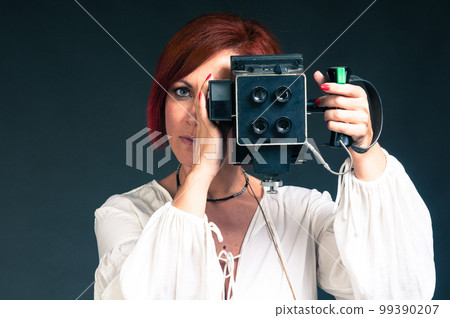 beautiful red-haired woman with a vintage photo camera beautiful red-haired woman with a vintage photo camera 99390207