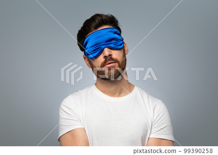 Sweet dreams concept. Asleep middle aged bearded man in sleep mask standing over grey background with closed eyes 99390258