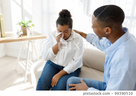African man psychologist supporting crying hispanic woman African man psychologist supporting crying hispanic woman 99390510