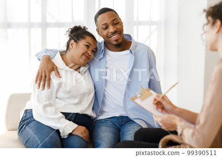 Cheerful african spouses attending therapy session together 99390511