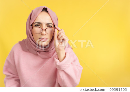 Muslim woman taking off her glasses to see Muslim woman taking off her glasses to see 99391503