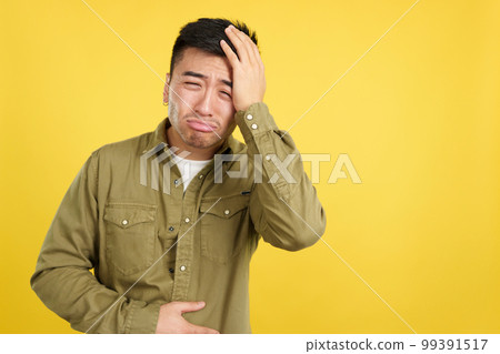Chinese man gesturing bodily discomfort and headache 99391517
