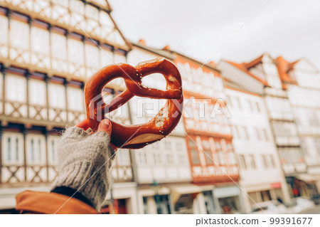 Pretzel and a typical german house in the background- Hannover, Lower Saxony, Germany, Europe Pretzel and a typical german house in the background- Hannover, Lower Saxony, Germany, Europe 99391677