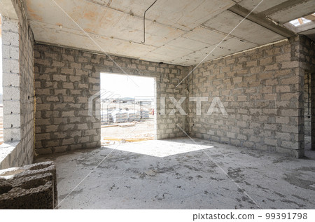 Construction of an individual residential building, view of a spacious room with a huge window opening Construction of an individual residential building, view of a spacious room with a huge window opening 99391798