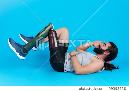 Man with a prosthetic leg doing sit-ups 99392238