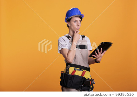 Female contractor with digital tablet browsing internet app, searching for building project on website. Construction worker using portable gadget with wireless network, industrial skill. 99393530