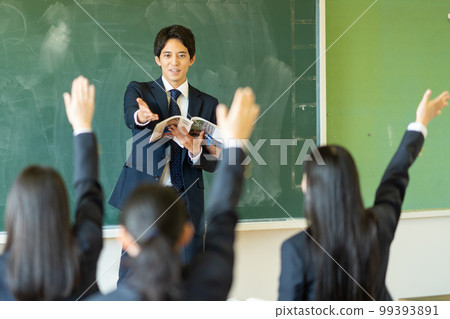 Male teacher teaching in a classroom 99393891