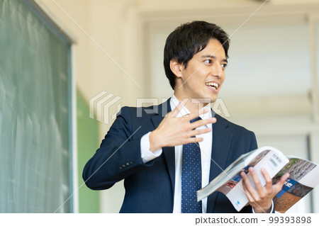 Male teacher teaching in a classroom 99393898
