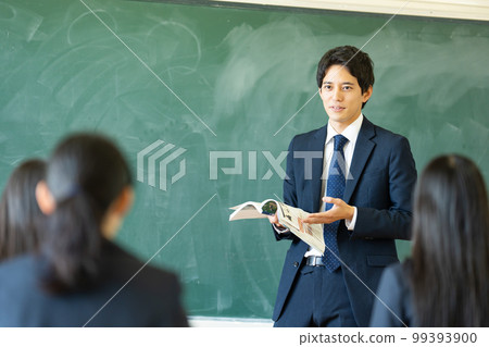 Male teacher teaching in a classroom 99393900
