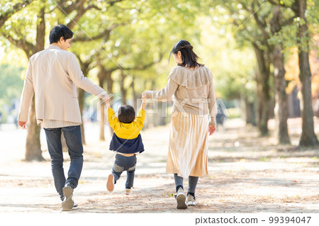 Back view of parents and children walking hand in hand Back view of parents and children walking hand in hand 99394047