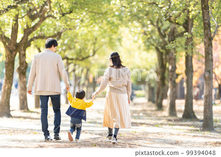 Back view of parents and children walking hand in hand 99394048