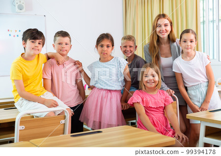 Group portrait of positive school children with teacher 99394178