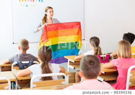 Positive female teacher standing with lgbt flag Positive female teacher standing with lgbt flag 99394336