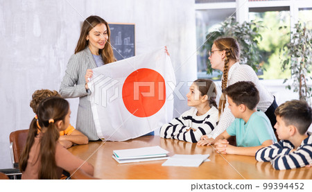 Teacher with flag of Japan tells story of the emergence of state Teacher with flag of Japan tells story of the emergence of state 99394452