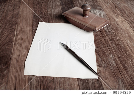 Vintage fountain pen and empty sheet of paper on a wooden table Vintage fountain pen and empty sheet of paper on a wooden table 99394539
