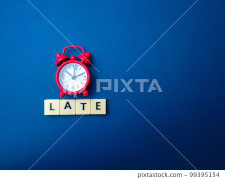 Red alarm clock with the word LATE on a blue background. Red alarm clock with the word LATE on a blue background. 99395154